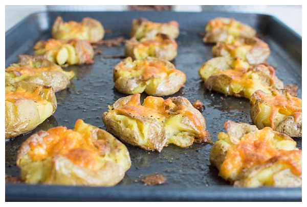 Loaded Smashed Potatoes -- crispy smashed potatoes topped with cheddar cheese, bacon, sour cream, and scallions. A fun side dish or perfect party appetizer!