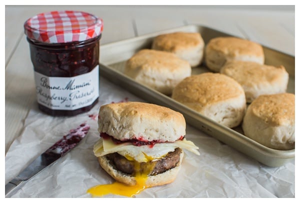 Sweet and Spicy Breakfast Sandwich with sausage, white cheddar, a fried egg, and raspberry preserves. Served on a buttermilk biscuit! 