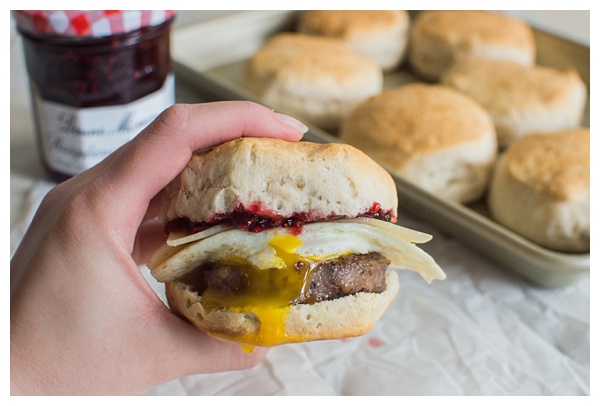 Sweet and Spicy Breakfast Sandwich with sausage, white cheddar, a fried egg, and raspberry preserves. Served on a buttermilk biscuit! 