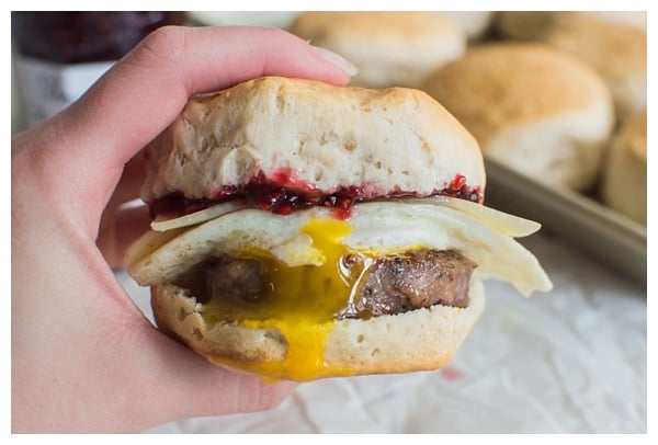 Sweet and Spicy Breakfast Sandwich with sausage, white cheddar, a fried egg, and raspberry preserves. Served on a buttermilk biscuit! 