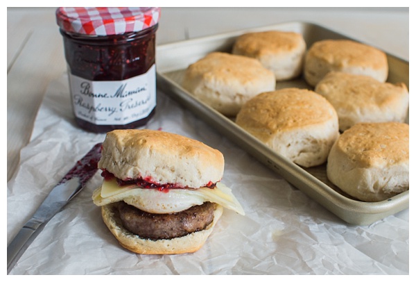 Sweet and Spicy Breakfast Sandwich with sausage, white cheddar, a fried egg, and raspberry preserves. Served on a buttermilk biscuit! 