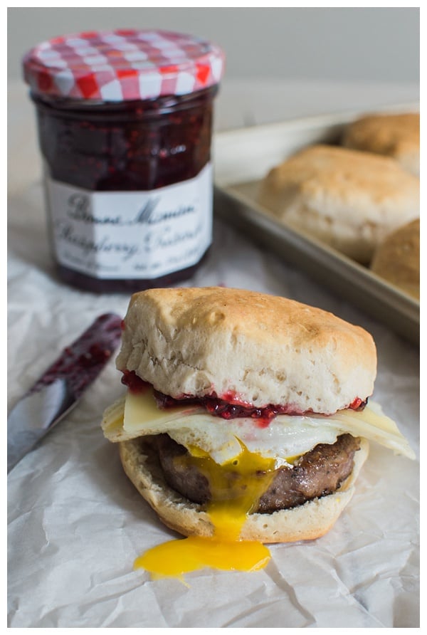 Sweet and Spicy Breakfast Sandwich with sausage, white cheddar, a fried egg, and raspberry preserves. Served on a buttermilk biscuit! 