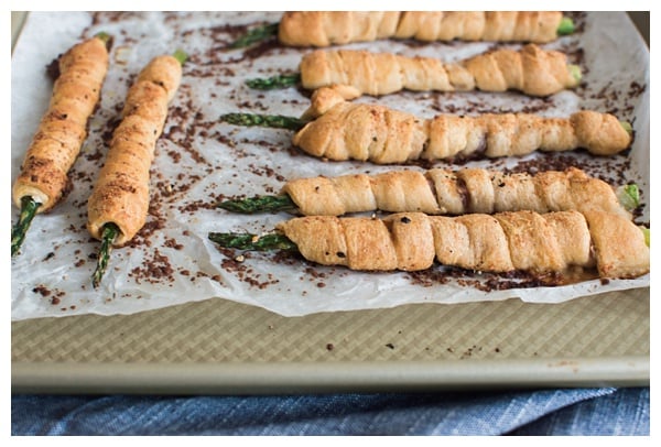 Asparagus Bundles -- Asparagus stalks wrapped in prosciutto, filled with garlic-herb cheese, rolled in crescent dough, topped with Parmesan and baked. A great appetizer, small bite or side dish!