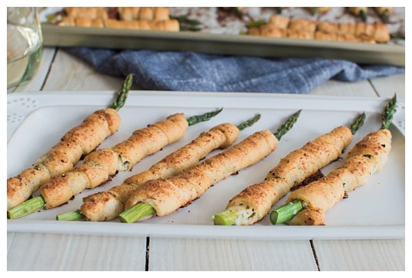 Asparagus Bundles -- Asparagus stalks wrapped in prosciutto, filled with garlic-herb cheese, rolled in crescent dough, topped with Parmesan and baked. A great appetizer, small bite or side dish!